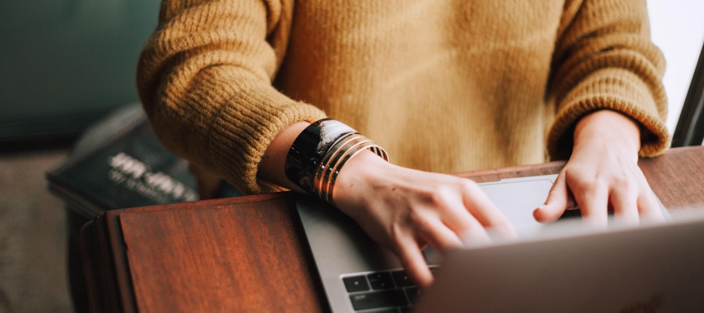 Student writing on a laptop